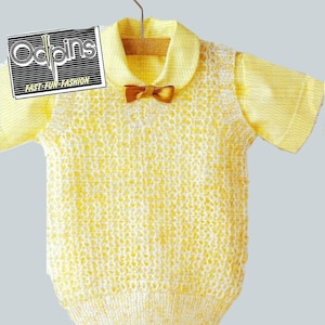 May include: A yellow baby outfit with a collared shirt and a knitted vest. The outfit has a small brown bow tie. The image also shows a pair of white shoes and a stack of folded towels.