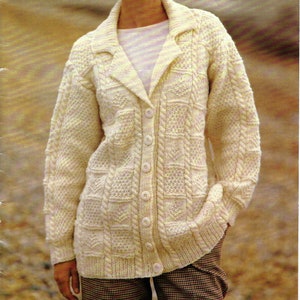 May include: A white knitted cardigan with a cable knit pattern and button closure. The cardigan has a wide collar and long sleeves.