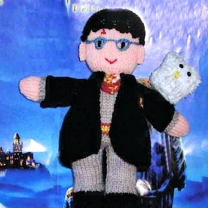 May include: Knitted Harry Potter doll with a white owl. The doll is wearing a black robe and glasses. The doll is sitting on a silver can.