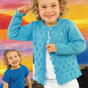 May include: A light blue knitted cardigan with a delicate lace pattern and button fastening. The cardigan is being worn by a young girl with curly blonde hair.