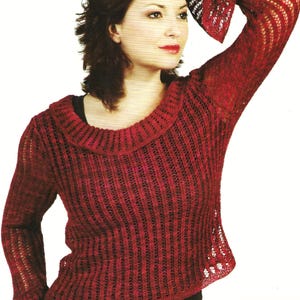 Könnte beinhalten: Ein roter Strickpullover mit Rundhalsausschnitt und langen Ärmeln. Der Pullover hat ein zartes Lochmuster und einen leicht ausgestellten Saum.