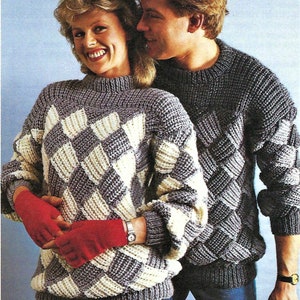 May include: A couple wearing matching knit jumpers with a diamond pattern. The woman is wearing red gloves and a watch. The man is wearing blue jeans.