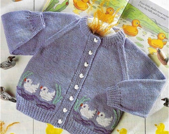 May include: A light purple knitted baby cardigan with white buttons and embroidered white ducks on the front. The cardigan has a ribbed collar and cuffs. The text "Four little ducks went swim Over the hills and far away." is visible in the background.