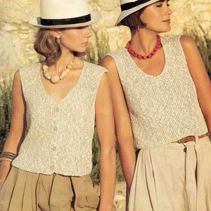 Puede incluir: Dos mujeres con tops de punto sin mangas y sombreros blancos. Las mujeres están de pie frente a una pared de piedra. Los tops son de color beige claro y tienen un patrón de punto texturizado. Los sombreros son de ala ancha y tienen una banda negra alrededor de la corona.