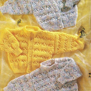 Puede incluir: Tres cárdigans de punto para bebé en diferentes colores. Uno es amarillo, otro es blanco con un patrón multicolor y el otro es blanco con un patrón multicolor. Los tres cárdigans tienen un cierre de botones en la parte delantera y un patrón de encaje.