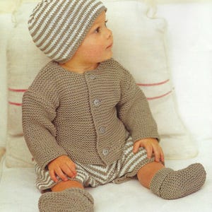 Puede incluir: Conjunto de bebé tejido en un color suave y neutro. El conjunto incluye una rebeca con botones, pantalones cortos, un gorro a rayas y patucos. Los pantalones cortos y el gorro presentan un estampado de rayas. El conjunto está diseñado para la comodidad y el calor.