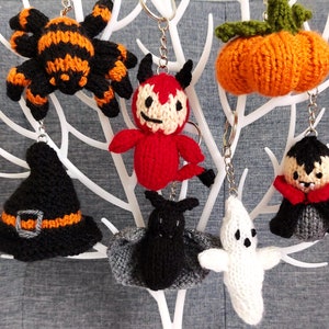 Può includere: Un set di dieci portachiavi in maglia a tema Halloween. I portachiavi rappresentano un ragno nero e arancione, un diavolo rosso, un cappello da strega nero e arancione, un pipistrello grigio e nero, un fantasma bianco, un vampiro nero e grigio e una zucca arancione.