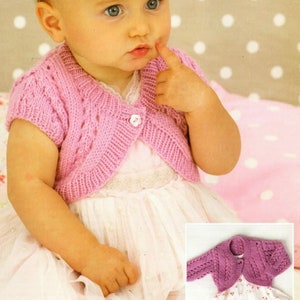 Puede incluir: Un cárdigan de punto rosa para bebé con mangas cortas y cierre de botón. El cárdigan está hecho con un delicado patrón de punto y tiene una longitud ligeramente recortada.