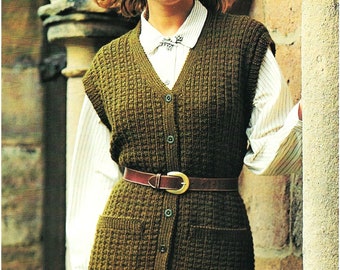 May include: A brown knitted vest with a button-up front and pockets. The vest is worn over a white button-down shirt and a brown leather belt.