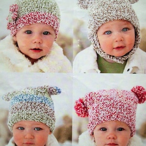 May include: Four babies wearing different knitted hats. The hats are all white with different colored accents. The hats are all made with a fluffy yarn.