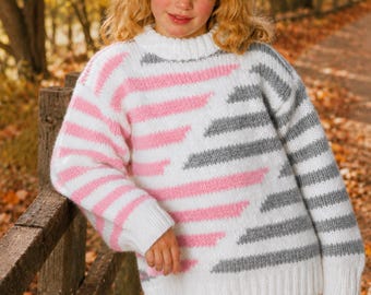 May include: A long-sleeved knit sweater featuring a white base with horizontal stripes in alternating pink and grey. The sweater has a ribbed crew neckline, ribbed cuffs, and a ribbed hem, constructed with a thick yarn texture and a relaxed fit.