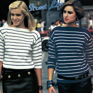 May include: Two women wearing striped sweaters. One sweater is white with navy stripes, the other is navy with white stripes. Both sweaters have a boat neck and three-quarter sleeves. The women are wearing black skirts and bracelets. The text "Street Life" is at the top.