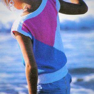 May include: A woman wearing a white, blue, and pink knitted sleeveless top with a blue denim skirt.