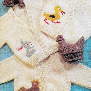 Pode incluir: Três cardigans de malha para bebé com diferentes desenhos de animais. Os cardigans são de cor creme com desenhos de animais castanhos, amarelos e cinzentos. Os cardigans têm botões na frente.