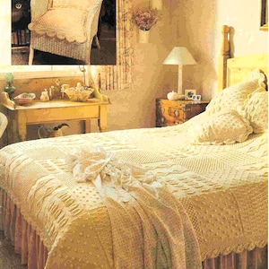 May include: A white wicker chair with a crocheted cushion and a white crocheted bedspread with a ruffled edge. The bedspread is on a bed with a wooden headboard and a white crocheted pillow.