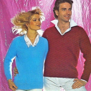 May include: A vintage image of a man and woman in knitwear. The woman wears a light blue V-neck sweater over a white collared shirt. The man is in a red V-neck sweater over a white collared shirt. The background is a pink, crinkled surface.