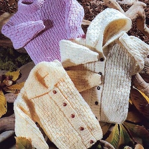 May include: Three knitted baby sweaters in different colors: a purple turtleneck sweater, a cream hooded cardigan, and a cream cardigan with a collar.