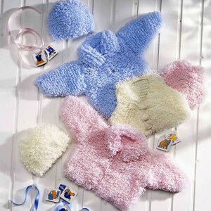 May include: Three knitted baby jackets in pink, blue and cream with matching hats. The jackets are made with a fluffy yarn and have a button closure.