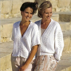 Può includere: Due donne indossano maglioni di pizzo bianco con un delicato motivo a pizzo. I maglioni hanno un collo a V e maniche corte. Le donne sono in piedi su una scalinata di pietra.