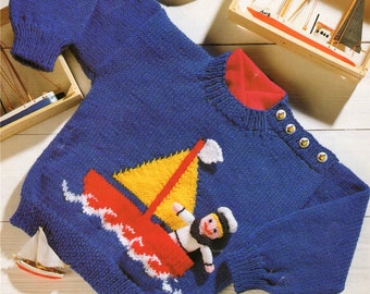 May include: A blue knitted sweater with a red sailboat and a sailor doll applique. The sweater has a red ribbed collar and buttons on the shoulder.