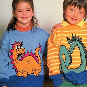 May include: Two children wearing knitted sweaters with dragon designs. The girl's sweater is blue with an orange dragon, and the boy's sweater is yellow and orange striped with a green dragon.