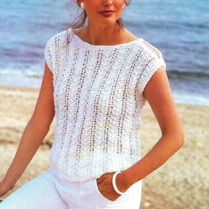 May include: A white crocheted top with a boat neck and short sleeves. The top features a delicate openwork pattern.