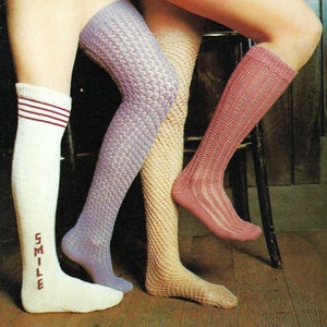May include: Three pairs of thigh-high stockings in different colors and patterns. One pair is white with red stripes and the word "SMILE" embroidered on the leg. Another pair is purple with a diamond pattern. The third pair is pink with a vertical ribbed pattern.