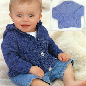 Op de afbeelding: Een baby draagt een marineblauwe vest met capuchon met kabelbreiwerk en drie witte knopen. De baby draagt ook een spijkerbroek. Een kleinere afbeelding toont een bijpassende blauwe trui.