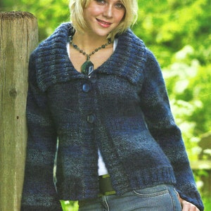 May include: A blue and gray knitted cardigan with a large collar and button closure. The cardigan is worn over a white shirt and blue jeans.