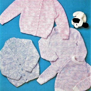 May include: Four knitted sweaters in pink and blue with a white background. Two of the sweaters are cardigans with buttons and two are crew neck sweaters.