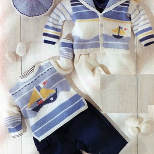 May include: A knitted baby outfit set in blue, white, and yellow with a sailboat design. The set includes a cardigan, a sweater, pants, and booties.