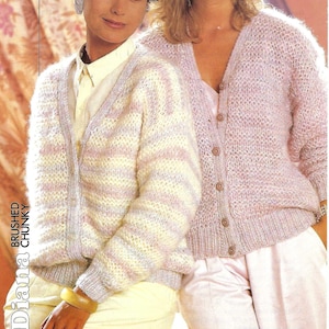 May include: Two women wearing striped and solid pink knitted cardigans with button fastenings. The cardigan on the left has a white, pink, and light blue striped pattern. The cardigan on the right is a solid pink colour. Both cardigans are made with a brushed chunky yarn.