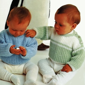 Può includere: Due bambini che indossano maglioni di lana. Un bambino indossa un maglione blu chiaro e l'altro un maglione a righe verdi e bianche.
