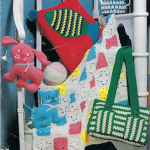 Puede incluir: Una colección de artículos de ganchillo hechos a mano, que incluyen una almohada roja con un diseño de pez, una manta colorida, un bolso tote a rayas verdes y blancas, un conejito rosa, un gato azul, una pelota y una tetera.