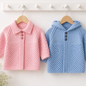 May include: Two long-sleeved knit jumpers hanging on wooden hangers. The left jumper is light pink with a classic collar and three buttons. The right jumper is light blue with an attached hood and three buttons. Both feature a textured knit pattern.