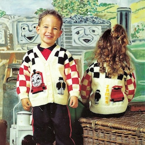 May include: Two children wearing cream-colored knitted cardigans with red and black checkered patterns. The cardigans feature embroidered images of Thomas the Tank Engine and a train conductor.