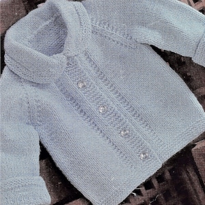 May include: A light blue knitted cardigan with a collar and button closure. The cardigan has a textured pattern and is made with a soft yarn.