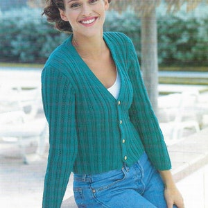 May include: A teal blue cardigan with a v-neck and button closure. The cardigan is knitted with a ribbed pattern and has long sleeves.