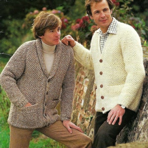 May include: Two men wearing knitted cardigans. The man on the left is wearing a brown and white cardigan with a shawl collar and a button closure. The man on the right is wearing a white cardigan with a button closure and a pocket on the front.