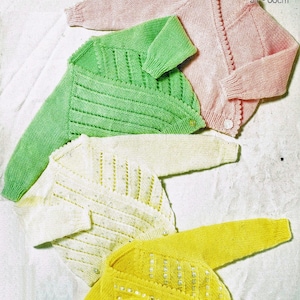 May include: Four knitted cardigans in different colors: pink, green, white, and yellow. The cardigans are laid out on a white surface. The pink cardigan has a button closure and a scalloped edge. The green cardigan has a criss-cross design. The white cardigan has a beaded design. The yellow cardigan has a beaded design.