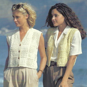 Peut inclure: Deux femmes portant des gilets en tricot sans manches. La femme de gauche porte un gilet blanc avec une fermeture à bouton. La femme de droite porte un gilet jaune avec une fermeture à bouton.