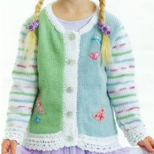 May include: A green and blue knitted cardigan with white trim and butterfly appliques. The cardigan has a button closure and striped sleeves.