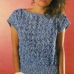 May include: A blue and white knit top with a short sleeve and a boat neck. The top has a textured pattern and is made of a soft, lightweight yarn.
