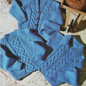 Könnte beinhalten: Zwei blaue Strickjacken mit einem Zopfmuster. Die Jacken haben einen V-Ausschnitt und einen Knopfverschluss.