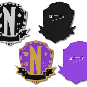 May include: Three different versions of a black and gold shield-shaped pin with a stylized letter N, a bird, a circle, and the numbers 17 and 91. The pins have a safety pin on the back.