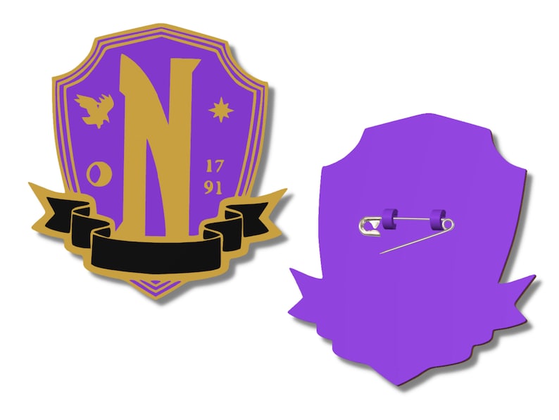 May include: Purple and gold shield-shaped pin with a gold letter N, a bird, a star, and the numbers 17 and 91. The back of the pin is purple and has a safety pin.