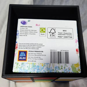 May include: A box of Saxon Facial Tissues with a floral design. The box is made of recycled paper and is certified by the Forest Stewardship Council (FSC). The box contains 56 sheets of 3-ply tissues. The box is made in the UK.