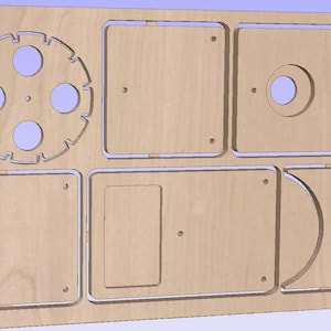 May include: A light-colored wooden panel with various cut-out shapes, including squares, rectangles, a circle, and a gear-like design. The panel appears to be a component for a larger project or a decorative element.