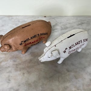 A matching pair of vintage Morland cast iron piggy bank money boxes