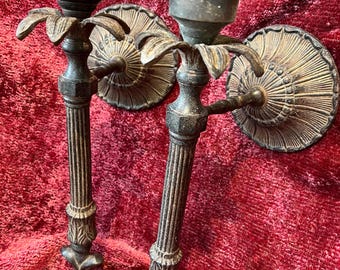Un par de candelabros de pared fijos de hierro fundido antiguos.